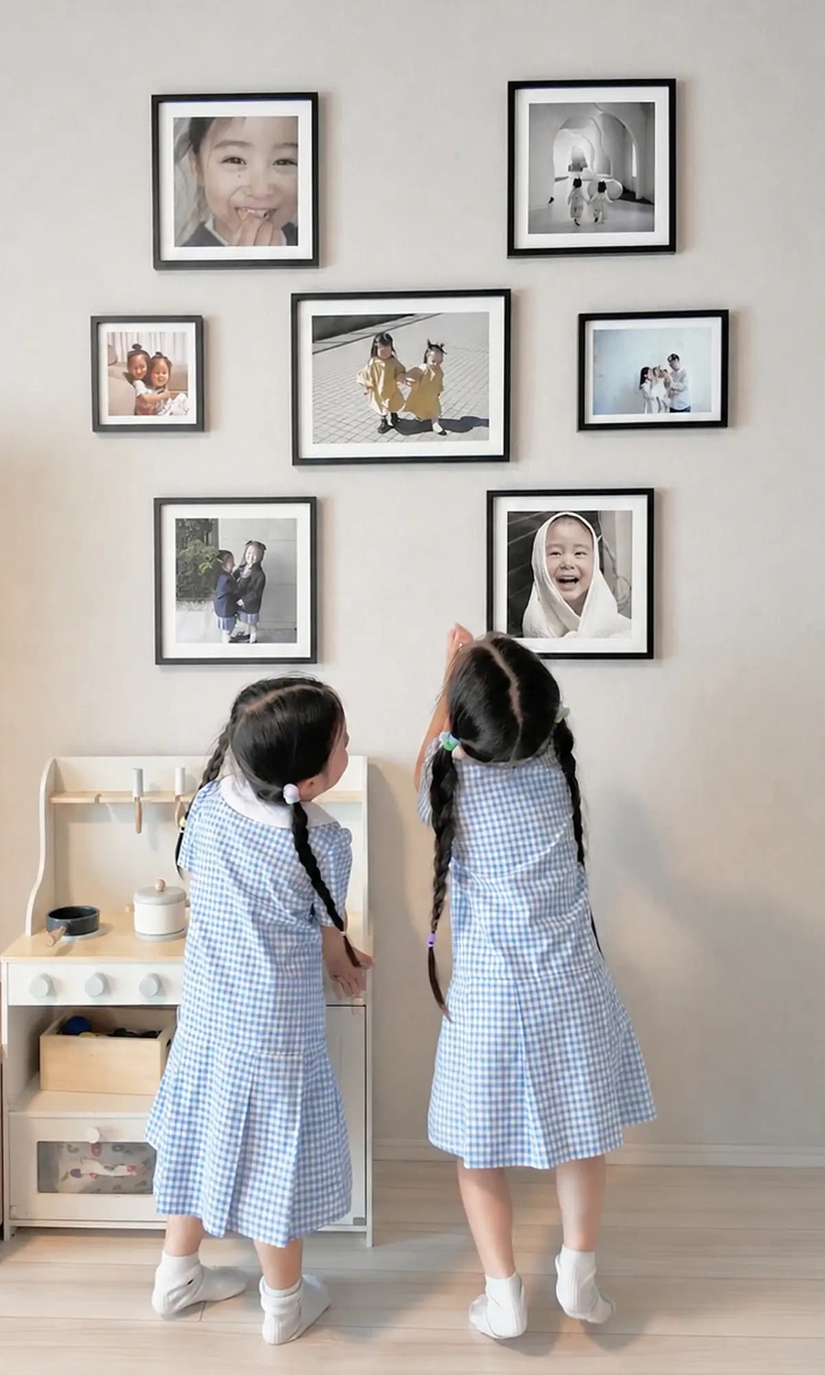 壁のフォトパネルを見る子供たち